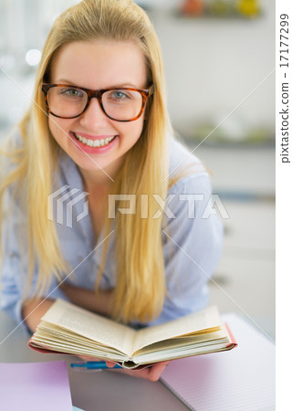 Portrait of happy young woman studying in kitchen Portrait of happy young woman studying in kitchen 17177299