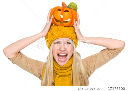 Girl in hat and scarf with jack-o-lantern on head Girl in hat and scarf with jack-o-lantern on head 17177300