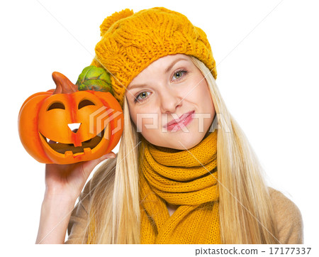 Girl in hat and scarf showing jack-o-lantern Girl in hat and scarf showing jack-o-lantern 17177337