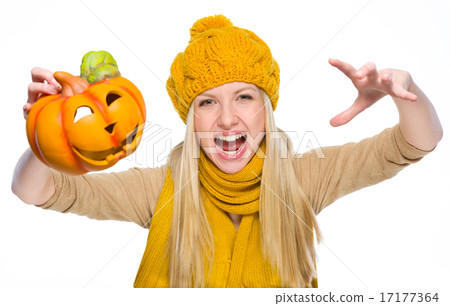 Girl in hat and scarf scaring with jack-o-lantern Girl in hat and scarf scaring with jack-o-lantern 17177364