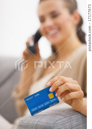 Closeup on credit card in hand of young woman talking phone Closeup on credit card in hand of young woman talking phone 17177673