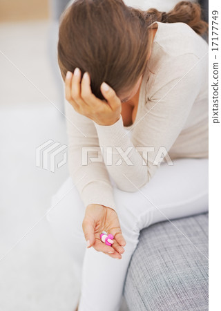 Closeup on pills in hand of stressed young woman 17177749