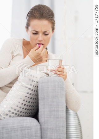 Young woman eating pill Young woman eating pill 17177759