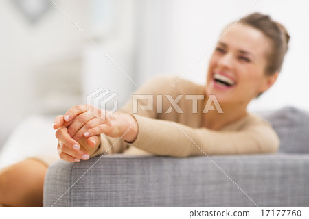 Closeup on hands of young woman sitting on divan Closeup on hands of young woman sitting on divan 17177760