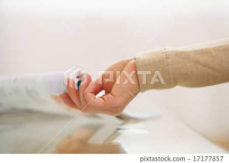 Closeup on hand of woman taking magazine from table Closeup on hand of woman taking magazine from table 17177857