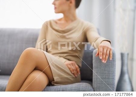 Closeup on young housewife sitting on couch Closeup on young housewife sitting on couch 17177864
