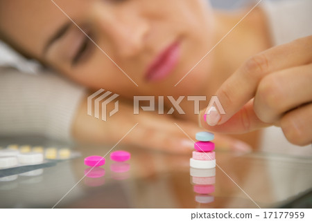 Closeup on young woman playing with pills Closeup on young woman playing with pills 17177959