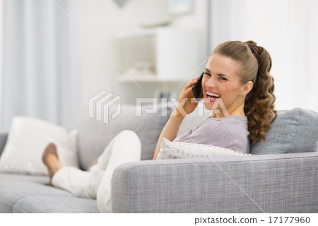 Portrait of happy young woman laying on divan and talking mobile Portrait of happy young woman laying on divan and talking mobile 17177960