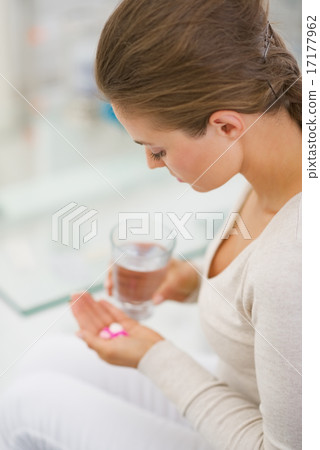 Young woman eating pills. rear view Young woman eating pills. rear view 17177962