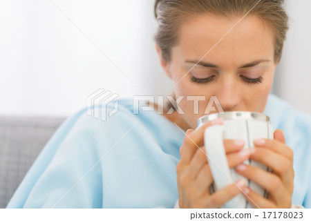 Ill young woman drinking hot beverage Ill young woman drinking hot beverage 17178023