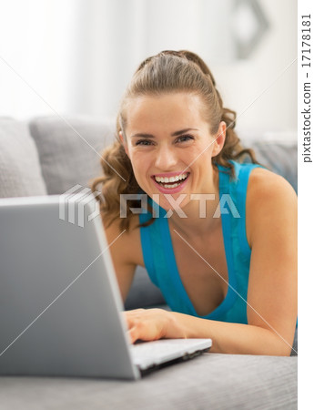 Young woman using laptop in living room Young woman using laptop in living room 17178181