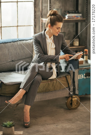Happy business woman using tablet pc in loft apartment Happy business woman using tablet pc in loft apartment 17178220