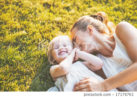 Happy mother and baby laying on meadow 17178761