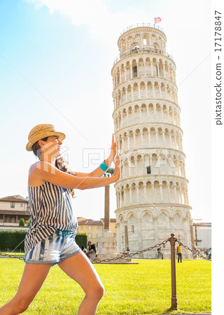 Funny young woman supporting leaning tower of pisa, tuscany, ita Funny young woman supporting leaning tower of pisa, tuscany, ita 17178847
