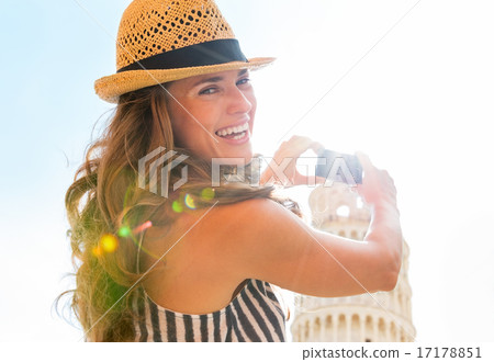 Young woman taking photo of leaning tower of pisa, tuscany, ital 17178851