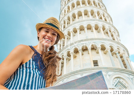 Portrait of happy young woman with map in front of leaning tower 17178860