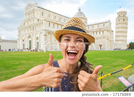 Portrait of happy young woman showing thumbs up on piazza dei mi 17178869