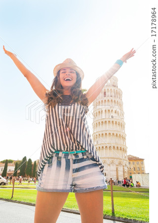 Happy young woman rejoicing in front of leaning tower of pisa, t 17178964