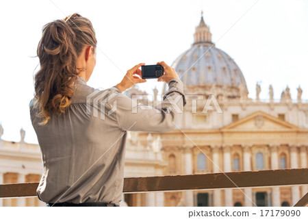 Young woman taking photo of basilica di san pietro in vatican ci 17179090