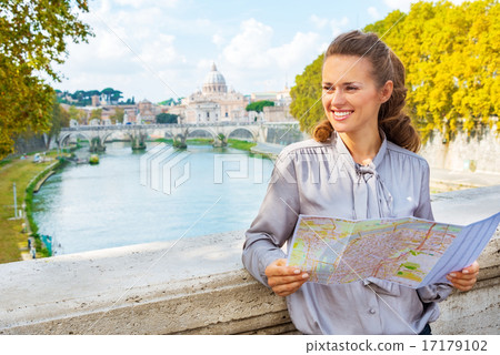 Happy young woman with map on bridge ponte umberto I with view o 17179102