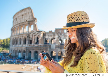 Happy young woman checking photos in camera in front of colosseu Happy young woman checking photos in camera in front of colosseu 17179109
