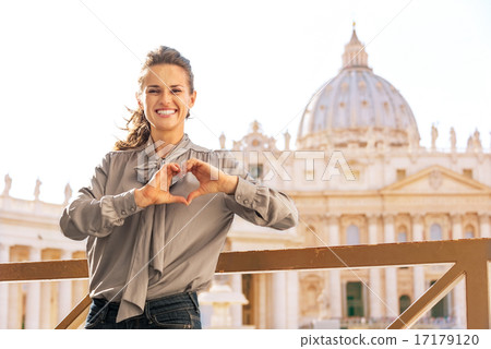 Happy young woman showing heart shaped hands in front of basilic 17179120