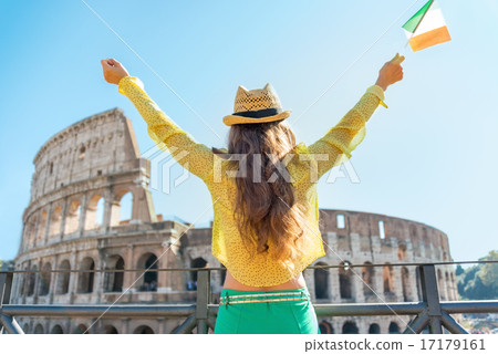 Young woman with italian flag rejoicing in front of colosseum in 17179161