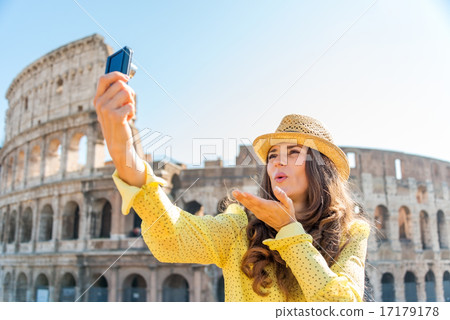 Woman tourist taking selfie blowing kisses at Rome Colosseum Woman tourist taking selfie blowing kisses at Rome Colosseum 17179178