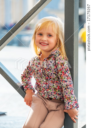 Portrait of happy baby girl sitting on street Portrait of happy baby girl sitting on street 17179267