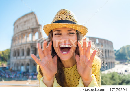 Happy young woman shouting through megaphone shaped hands in fro Happy young woman shouting through megaphone shaped hands in fro 17179294