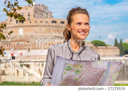 Portrait of happy young woman with map on embankment near castel 17179319