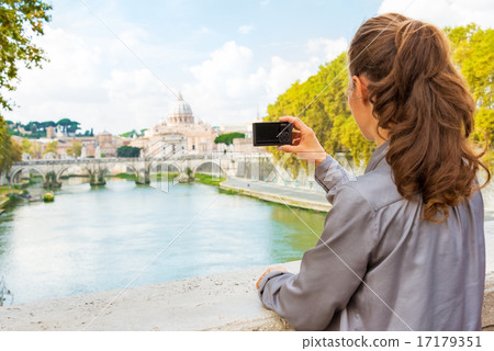 Young woman taking photo while on bridge ponte umberto I with vi 17179351