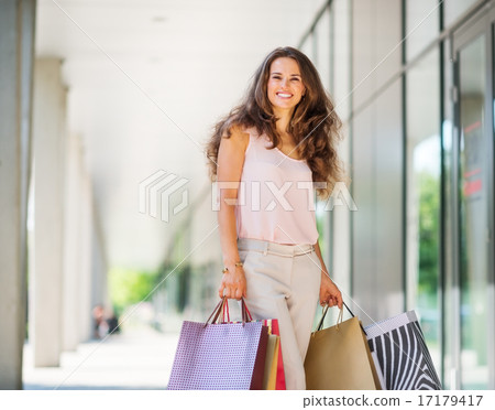 Stock Photo: Brown-haired woman smiling about her successful shopping spree