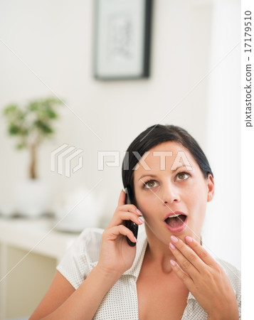 Surprised young woman speaking mobile phone Surprised young woman speaking mobile phone 17179510