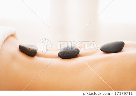 Closeup on young woman receiving hot stone massage 17179711