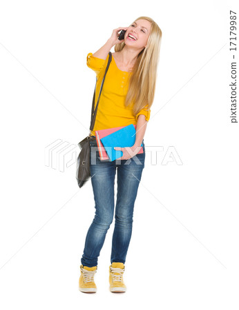 Full length portrait of smiling student girl talking mobile phon 17179987