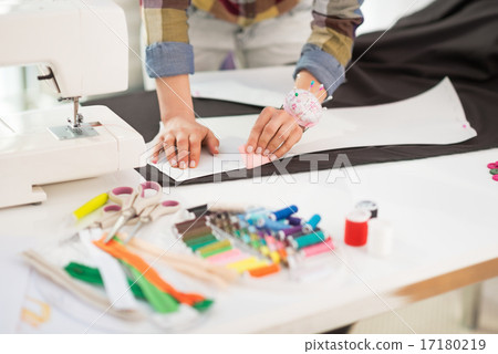 Closeup on seamstress making pattern on fabric Closeup on seamstress making pattern on fabric 17180219