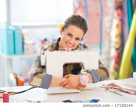 Happy seamstress embracing sewing machine Happy seamstress embracing sewing machine 17180244