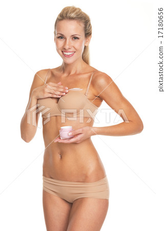 Happy young woman in lingerie applying creme on breast Happy young woman in lingerie applying creme on breast 17180656