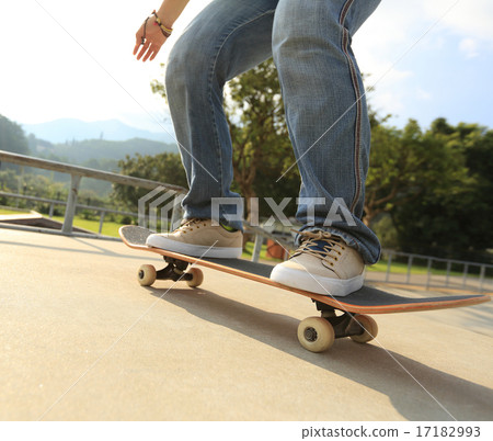 skateboarder legs doing a trick ollie at skatepark skateboarder legs doing a trick ollie at skatepark 17182993