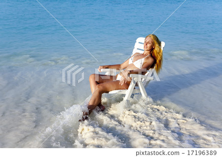 Young pretty woman in a beach chair in sea 17196389