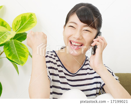 Female guts pose talking on smartphone in room Female guts pose talking on smartphone in room 17199021