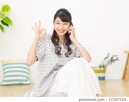 女性好的標誌在房間裡的智能手機上發言 17207539