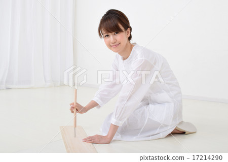 A woman drilling a hole in a plate with a chestnut 17214290