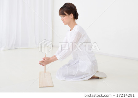 A woman drilling a hole in a plate with a chestnut A woman drilling a hole in a plate with a chestnut 17214291