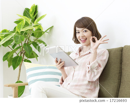 Female OK sign using tablet in room 17216693