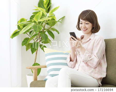 A woman using a smartphone in a room A woman using a smartphone in a room 17216694