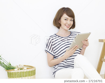 使用片劑的一名婦女在屋子裡 17216701