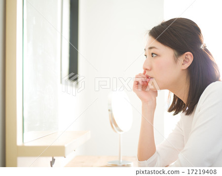A young lady looking at a beauty mirror 17219408