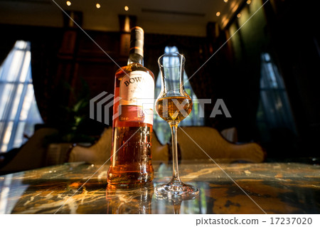 Whiskey glasses and bottles shining in sunset Whiskey glasses and bottles shining in sunset 17237020